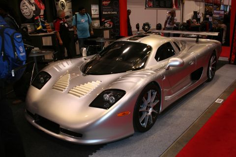 1998 Ford Crown Victoria - A striking silver supercar, likely a custom build or exotic model, is displayed indoors with a prominent rear spoiler and unique front air…