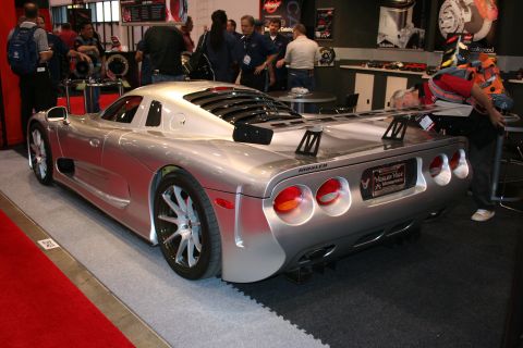 1998 Ford Crown Victoria - A silver Mosler sports car is displayed at an event, with people in the background.