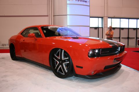 1998 Ford Crown Victoria - A man stands in the background near a bright orange Dodge Challenger with custom wheels.