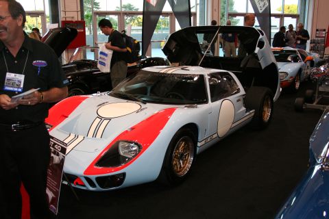 1998 Ford Crown Victoria - A light blue and orange Ford GT40 race car is displayed with its doors open at an indoor event.