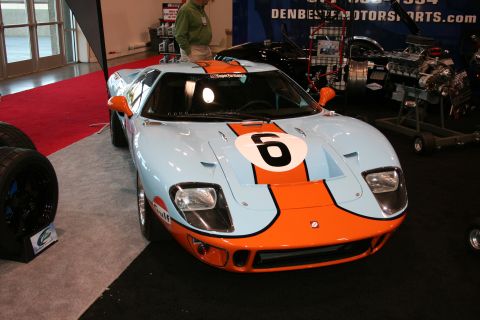 1998 Ford Crown Victoria - A light blue and orange Ford GT40 race car, number 6, is displayed indoors.