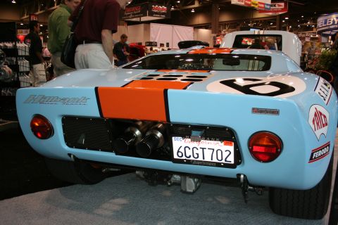 1998 Ford Crown Victoria - A light blue Ford GT40 replica with racing decals and dual exhaust pipes is displayed indoors.