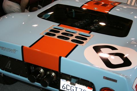 1998 Ford Crown Victoria - A light blue and orange race car, likely a Ford GT40, is viewed from the rear with prominent racing stripes and the number 6.