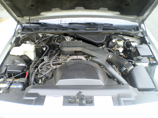 1992 Ford Crown Victoria engine bay with hood open, showing V8 engine, air intake, battery, and various hoses