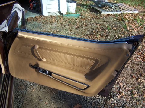 1991 Ford LTD Crown Victoria - The interior door panel of a classic car shows tan upholstery and chrome accents.
