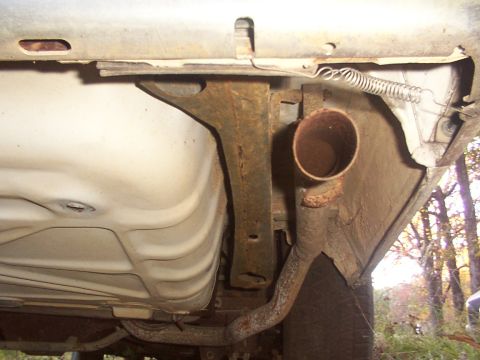 1991 Ford LTD Crown Victoria - Undercarriage view shows the exhaust pipe and fuel tank of a vehicle.