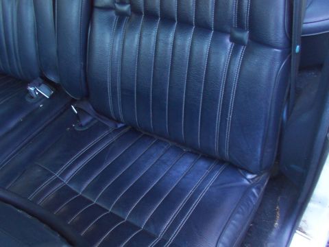 1991 Ford LTD Crown Victoria - The interior of a car shows dark blue vinyl seats with white stitching, indicating a vintage vehicle.