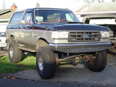 1989 Ford Bronco - This lifted 1987 Ford Bronco features a two-tone paint scheme and prominent aftermarket wheels and tires.