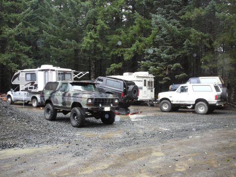 1991 Ford Bronco - A camouflaged Ford Bronco is parked in a gravel lot with other vehicles and RVs.