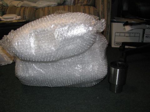 2003 Mercury Marauder - An engine intake part is shown wrapped in bubble wrap, with a metal cylinder beside it.