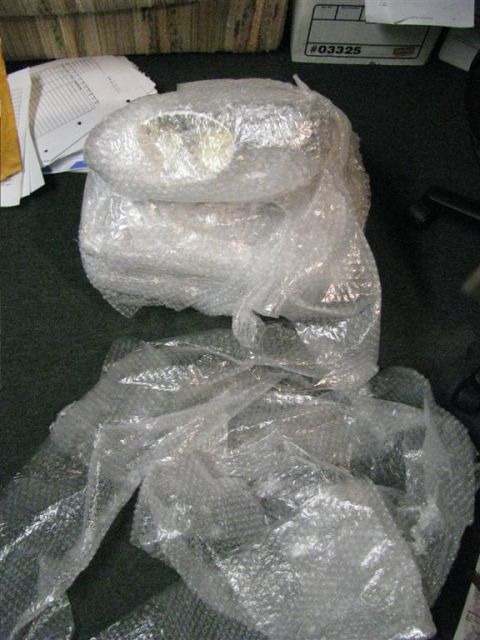 2003 Mercury Marauder - Unidentified car part wrapped in bubble wrap, with a box labeled "#03325" in the background.