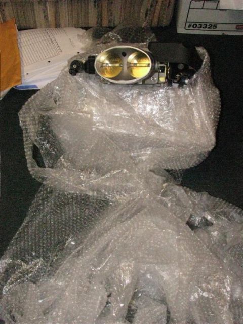 2003 Mercury Marauder - A throttle body, likely for an engine, is shown wrapped in bubble wrap.