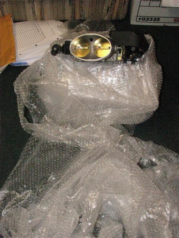 Throttle body with dual butterflies, wrapped in bubble wrap