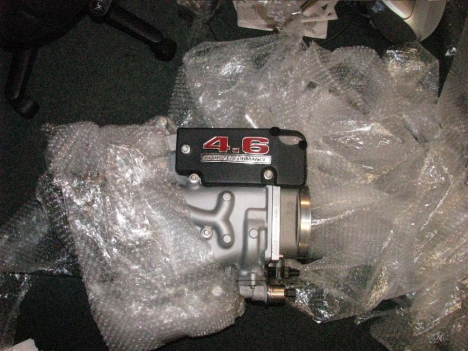 Engine intake part with "4.6 HIGH PERFORMANCE" label, wrapped in bubble wrap