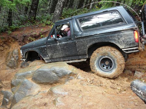 1991 Ford Bronco - This 1991 Ford Bronco tackles a challenging off-road course with steep inclines and muddy terrain.