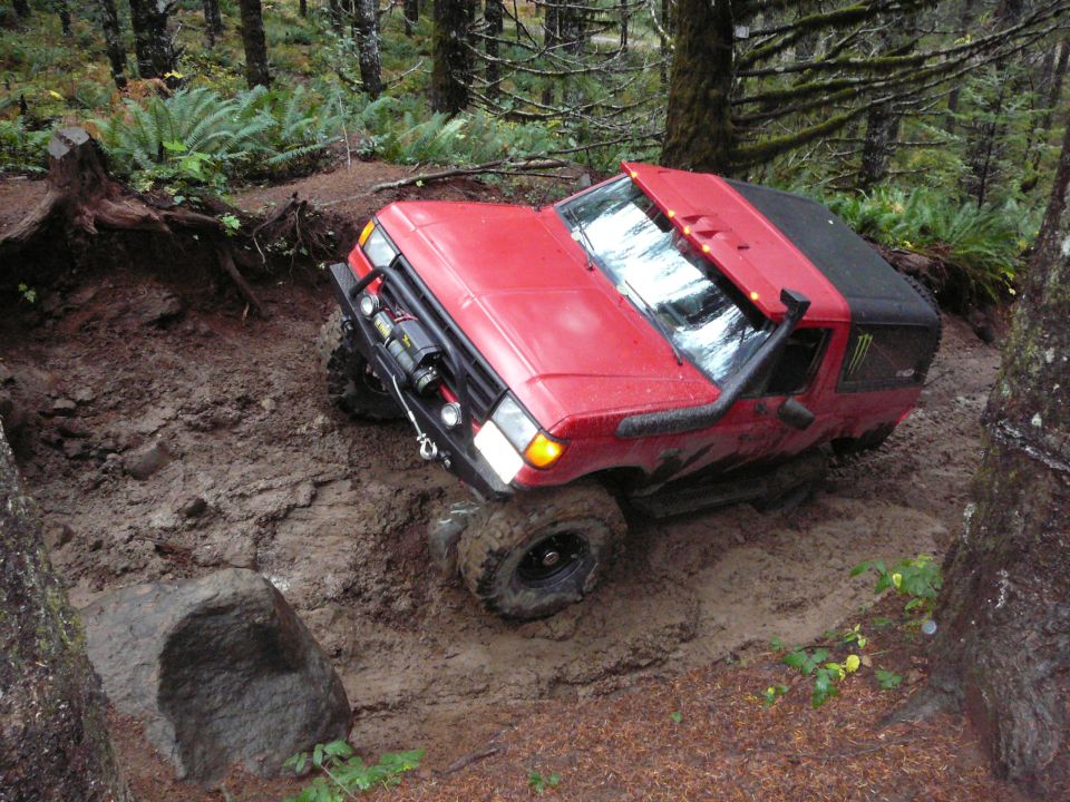 1991 Ford Bronco navigating a muddy trail with snorkel and winch