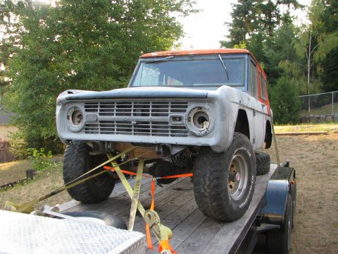 1967 Ford Bronco - This 1967 Ford Bronco is being transported on a trailer, showing its iconic front grille and body style.
