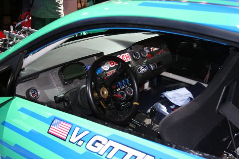 1998 Ford Crown Victoria - The interior of a modified vehicle features racing gauges and a digital dashboard display.