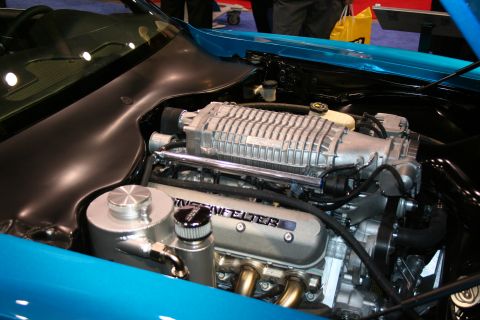 1998 Ford Crown Victoria - Close-up of a modified engine bay, showing a supercharger and custom valve covers.