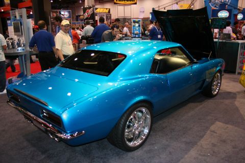 1998 Ford Crown Victoria - A bright blue 1969 Chevrolet Camaro coupe is displayed with its hood open at an automotive show.