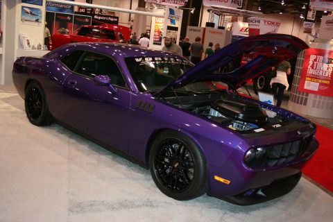 1998 Ford Crown Victoria - Purple Dodge Challenger on display at an auto show, hood raised to reveal the engine.