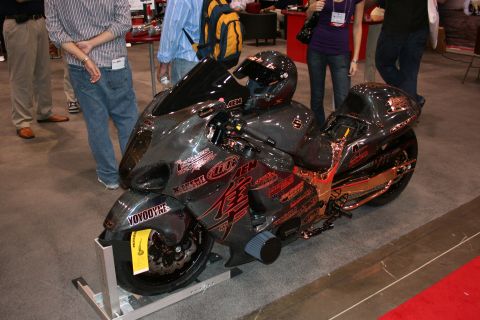 1998 Ford Crown Victoria - A highly customized motorcycle, adorned with numerous racing decals, is displayed with a helmet resting on its seat.