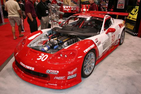 1998 Ford Crown Victoria - A red and white race car with the hood open is displayed indoors.