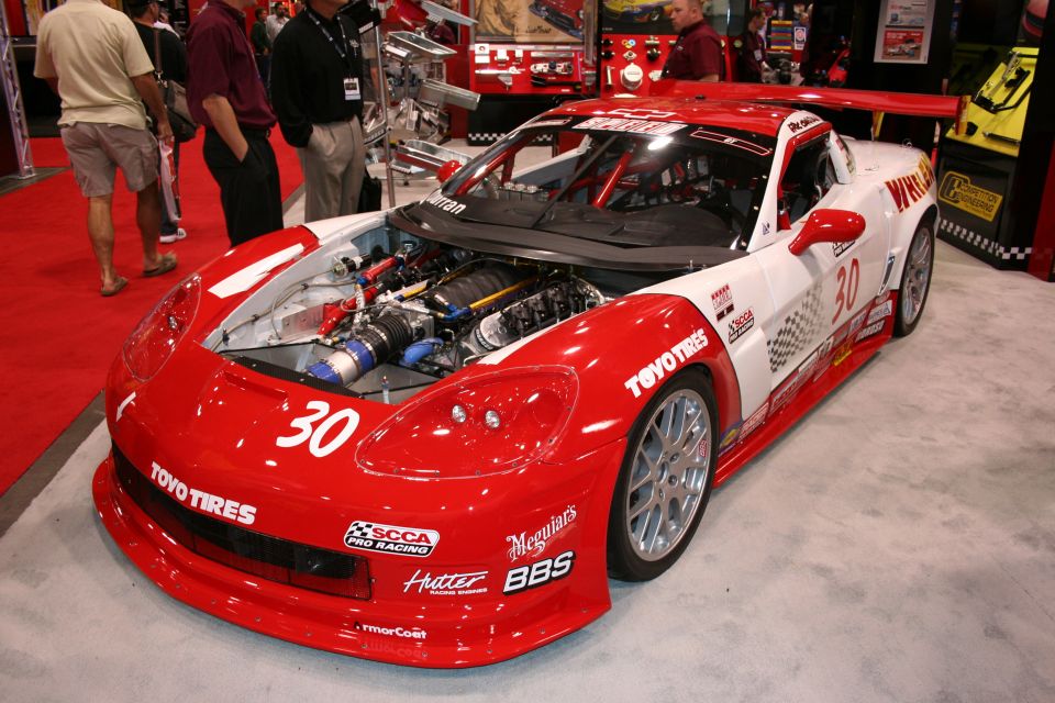 Red and white race car with hood open, showing engine. Number 30 visible