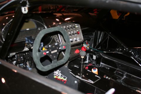 1998 Ford Crown Victoria - Interior view of a racing car, a suede steering wheel, racing shifter, and a panel of dashboard buttons.