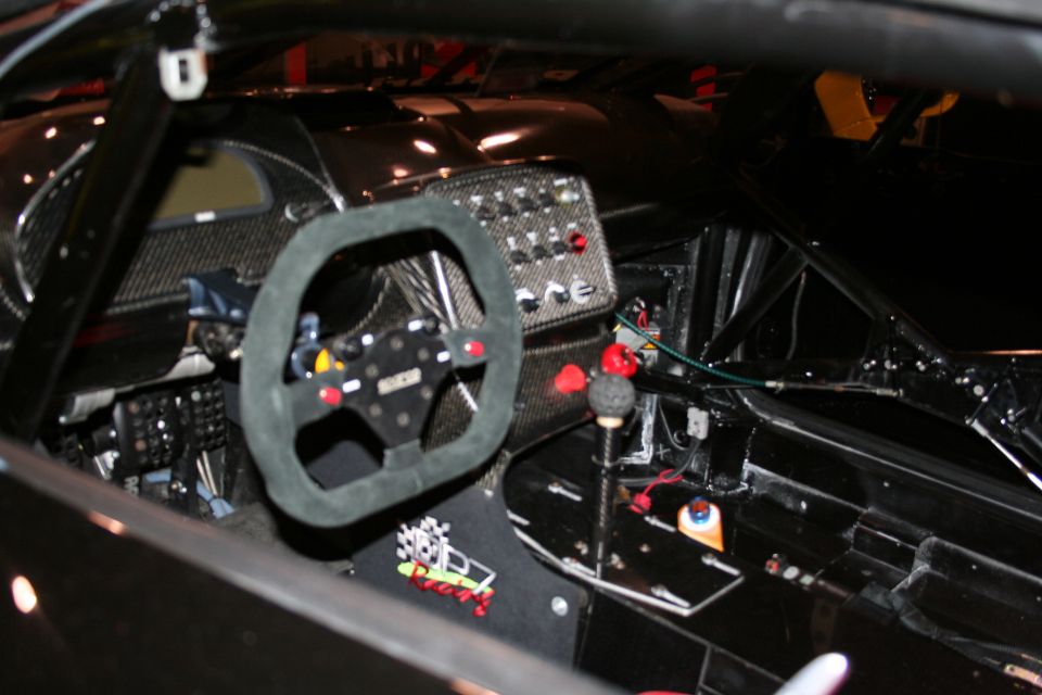 Racing car interior with suede steering wheel, racing shifter, and dashboard buttons
