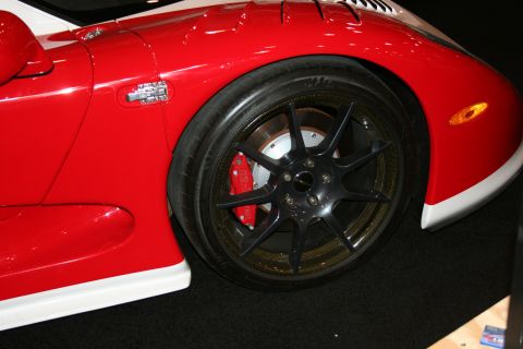1998 Ford Crown Victoria - Close-up of a red sports car's front fender and wheel assembly.