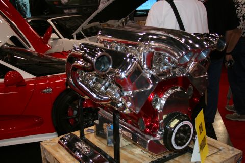 1998 Ford Crown Victoria - A highly polished V8 engine with a prominent supercharger is displayed, with other vehicles visible in the background.