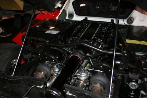1998 Ford Crown Victoria - Close-up view of a powerful twin-turbocharged V8 engine, prominent black intake piping and gleaming chrome wastegates.