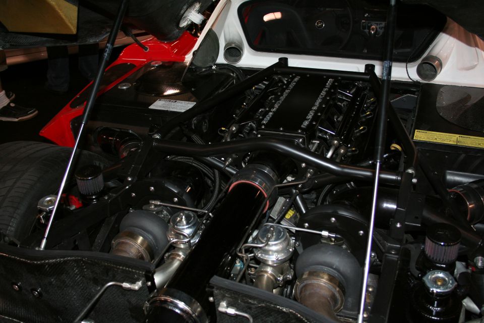 Twin-turbocharged V8 engine with black intake piping and chrome wastegates