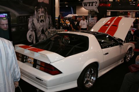 1998 Ford Crown Victoria - A white sports car with red racing stripes is displayed with its hood open.