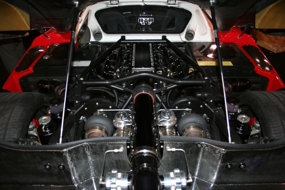 Twin-turbocharged V12 engine with red accents and carbon fiber components