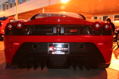 1998 Ford Crown Victoria - Rear view of a red sports car a black rear diffuser and dual exhaust pipes.