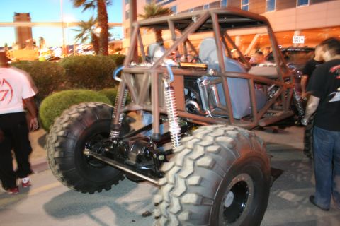 1998 Ford Crown Victoria - A custom-built off-road buggy with a prominent roll cage and oversized tires is parked outdoors.