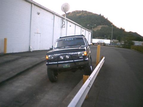 1988 Ford Bronco - This black 1988 Ford Bronco is parked at an angle, with its front wheels on yellow blocks.