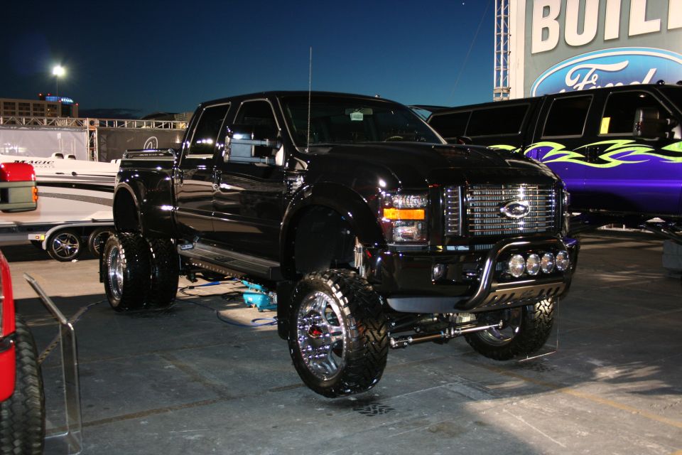 Black lifted dually pickup truck with chrome grille and wheels