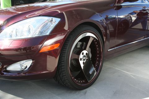 1998 Ford Crown Victoria - Close-up of a customized luxury sedan's front quarter panel and large chrome wheels.