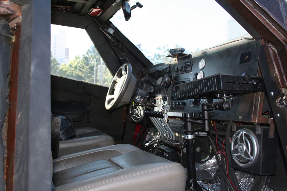 Interior view of a heavily modified vehicle with custom dashboard, multiple levers, and aftermarket seats