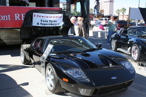 1998 Ford Crown Victoria - A black Ford GT sports car is displayed with its engine cover open, revealing a sign about its modifications.