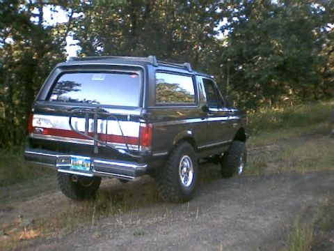 1988 Ford Bronco - This black Ford Bronco is shown from the rear, equipped with a bike rack mounted on the tailgate.