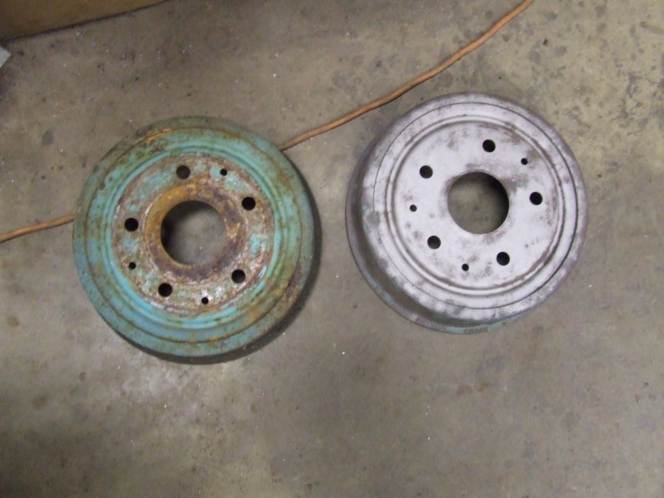 Rusty blue and clean gray brake drums side-by-side