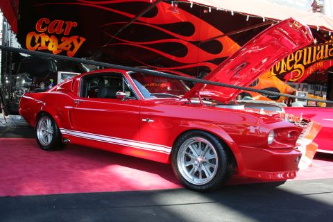 1998 Ford Crown Victoria - A classic red Ford Mustang is displayed with its hood open, its engine bay.