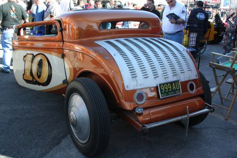 1998 Ford Crown Victoria - This custom hot rod features a distinctive orange paint job and racing number 10 on its side, viewed from the rear.