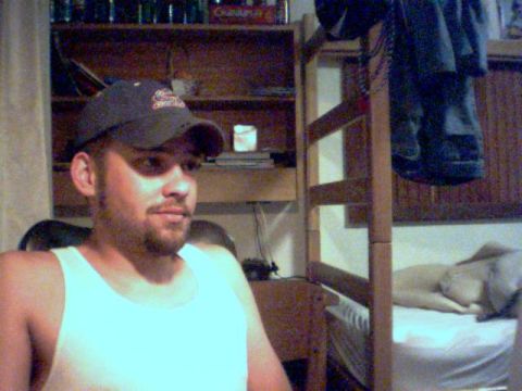 1988 Ford Bronco - A man in a tank top and baseball cap is in a room with a bunk bed in the background.