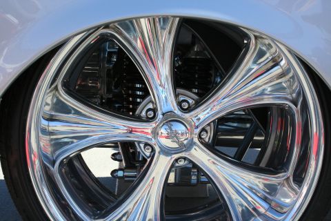 1998 Ford Crown Victoria - A highly polished custom wheel with intricate detailing is shown on a vehicle.