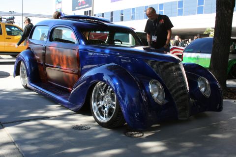1998 Ford Crown Victoria - A custom hot rod with a unique blue paint job and flame graphics is displayed outdoors.